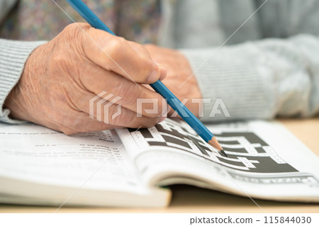 Alzheimer disease AD, Asian elderly woman playing sudoku puzzle game to practice for dementia prevention. 115844030