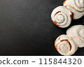 Fragrant Cinnabons with cream on a gray background 115844320
