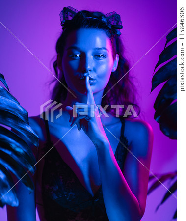 Mysterious Model in Black Lace Lingerie Posing with Neon Blue and Pink Lighting Mysterious Model in Black Lace Lingerie Posing with Neon Blue and Pink Lighting 115846306