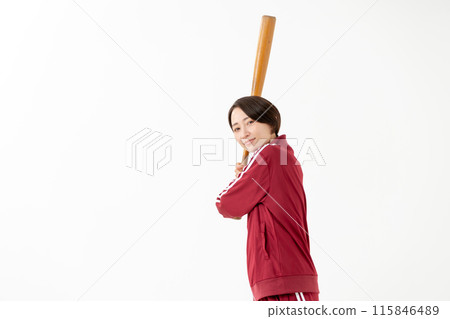 Woman in a jersey swinging a bat 115846489