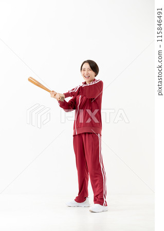 一個穿著球衣的女人揮舞著球棒 115846491