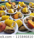 A dessert dish at an event consisting of boiled corn, boiled keledek, and boiled banana served on a plastic plate. 115846810