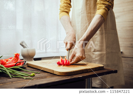 Unrecognizable man chopping bell pepper with kitchen knife in the kitchen 115847221
