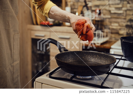 Unrecognizable man moving chopped chicken fillet on a frying pan Unrecognizable man moving chopped chicken fillet on a frying pan 115847225