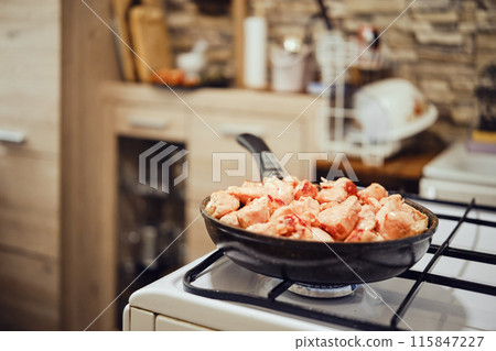 Chopped chicken fillet in frying pan on a gas stove Chopped chicken fillet in frying pan on a gas stove 115847227