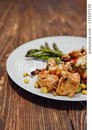 Close-up view of spicy chicken ragout with vegetables and fried asparagus Close-up view of spicy chicken ragout with vegetables and fried asparagus 115847239