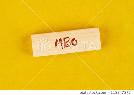 Management by Objectives MBO written on wooden blocks on a bright yellow mustard background Management by Objectives MBO written on wooden blocks on a bright yellow mustard background 115847872