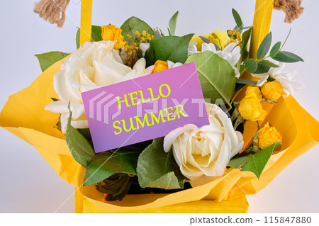 Conceptual hello summer symbol. HELLO SUMMER on a purple business card in a basket with flowers 115847880