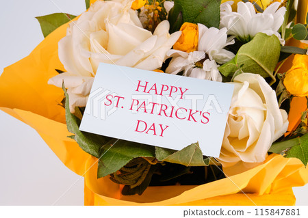 Celebration of St. Patrick's Day on a card hidden in a bouquet of beautiful flowers Celebration of St. Patrick's Day on a card hidden in a bouquet of beautiful flowers 115847881