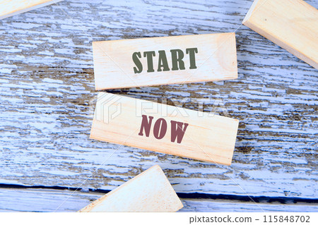 Concept words Success Starts Now. Psychological social and Success Starts Now concept written a conceptual phrase on wooden blocks lying on old boards 115848702