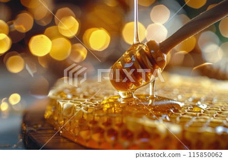 Golden Honey Dripping From a Dipper Onto Honeycomb Golden Honey Dripping From a Dipper Onto Honeycomb 115850062