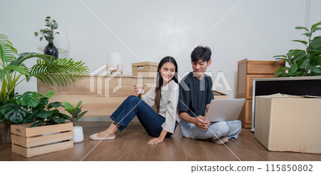 Happy Couple Moving into New Home, Unpacking Boxes and Setting Up Furniture in Modern Living Room Happy Couple Moving into New Home, Unpacking Boxes and Setting Up Furniture in Modern Living Room 115850802