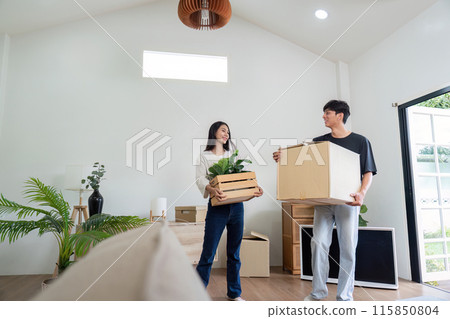 Happy Couple Moving into New Modern House with Boxes and Plants, Starting Fresh in Their New Home 115850804