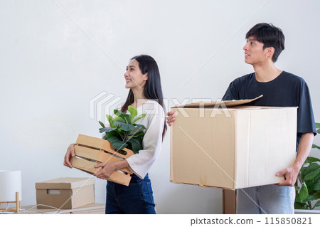 Young Couple Moving into New House, Carrying Boxes and Plants, Starting Fresh in Their Modern Home 115850821