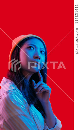 Skeptic face. Idea contemplation. Blue pink neon light pensive girl considering solution isolated on red copy space background. 115851411