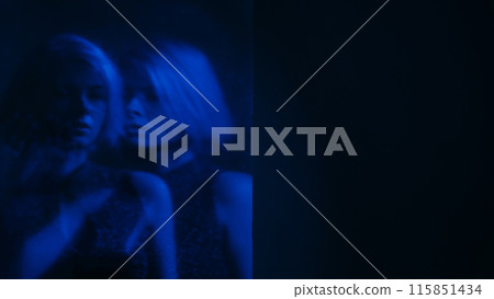 Dual personality. Blur silhouette. Internally suffering sad woman out of focus mental disorder neon blue color double exposure dark free space. 115851434