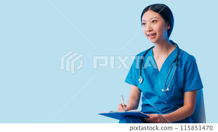 Medical consultation. Healthcare checkup. Happy woman doctor uniform sitting talking listening patient writing notes diagnosis isolated on blue empty space background. Medical consultation. Healthcare checkup. Happy woman doctor uniform sitting talking listening patient writing notes diagnosis isolated on blue empty space background. 115851470