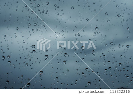 Raindrops on window against cloudy gray sky. Cinematic dramatic background 115852216