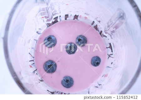 Mixed sweet blueberries with yoghurt and seeds in a blender cup, top view. 115852412