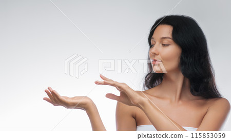 Graceful Woman with Long Black Hair Presenting Product with Poised Hands 115853059