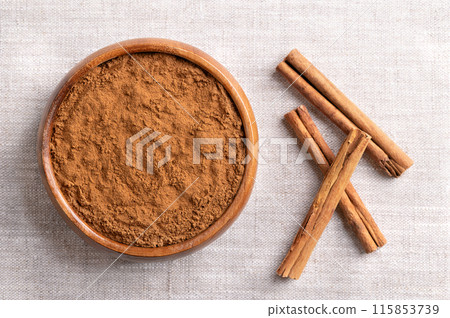 Ceylon cinnamon powder in a wooden bowl on linen. Ground bark of Ceylon cinnamon, Cinnamomum verum, and dried whole bark strips on the right. Used mainly as aromatic condiment and flavouring additive. Ceylon cinnamon powder in a wooden bowl on linen. Ground bark of Ceylon cinnamon, Cinnamomum verum, and dried whole bark strips on the right. Used mainly as aromatic condiment and flavouring additive. 115853739