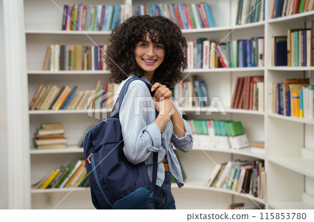 Cute woman in the library smiling nicely and looking contented 115853780