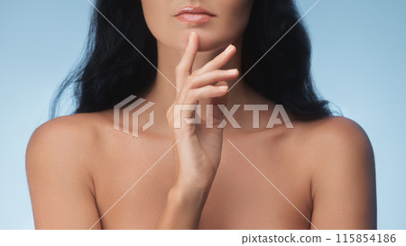 Close-Up of Woman's Chin and Hand on Blue Background Close-Up of Woman's Chin and Hand on Blue Background 115854186
