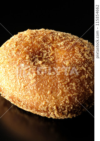 Curry bread photographed against a black background 115854662