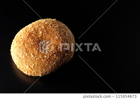 Curry bread photographed against a black background 115854673