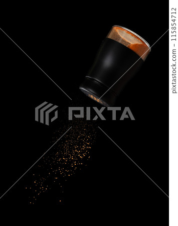 Chilli seasoning powder flavor falling from shaker bottle, red chilli and seasoning powder splash in mid air. Seasoning powder shaker spice up taste of food over black background isolated 115854712
