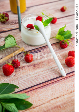 homemade sweet yogurt in a jar with strawberries, on a wooden table 115855014