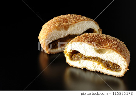黑色背景下咖哩麵包切成兩半的照片 黑色背景下咖哩麵包切成兩半的照片 115855178