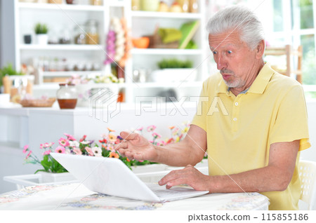Portrait of senior man with laptop at home Portrait of senior man with laptop at home 115855186