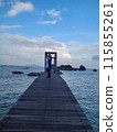 A photo of a person standing on a wooden bridge with an idyllic sea view 115855261