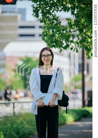 Young woman walking with a computer 115855938