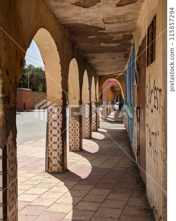Typical colonnade at the facade of houses in downtown of the city Tata 115857294