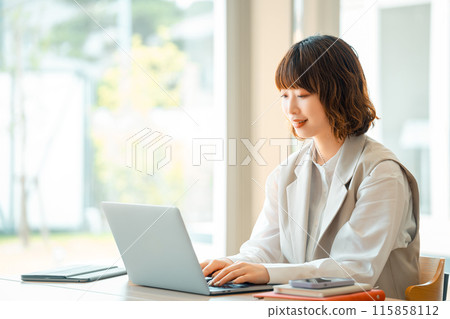 Smiling business woman using a computer 115858112