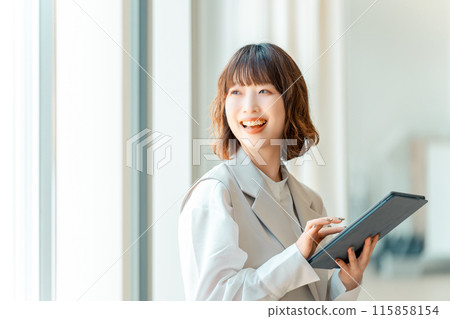 Smiling businesswoman using a tablet 115858154