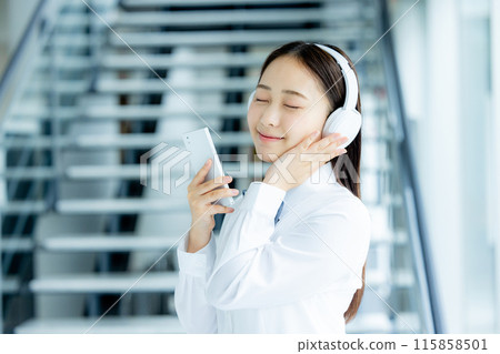 School girls listening to music with headphones 115858501