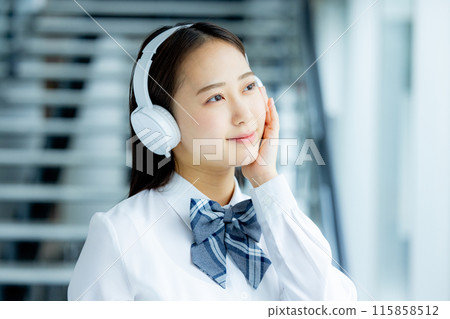 School girls listening to music with headphones 115858512