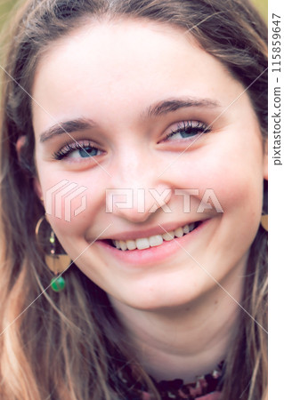 Capturing a candid portrait of a cheerful young woman with a genuine smile and vibrant expression 115859647