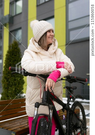 Woman Standing Next to Bike in Snow Woman Standing Next to Bike in Snow 115860058