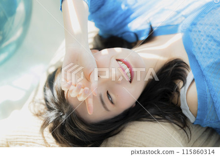 一個穿著藍色衣服的女人仰躺著 115860314