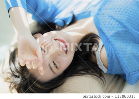 A woman in blue clothes lying on her back A woman in blue clothes lying on her back 115860315