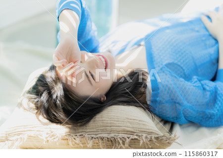 A woman in blue clothes lying on her back A woman in blue clothes lying on her back 115860317