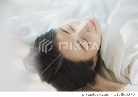 Woman lying on bed 115860370