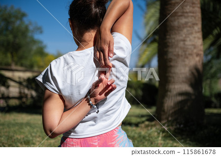 Woman practicing yoga stretches outdoors on a sunny day 115861678