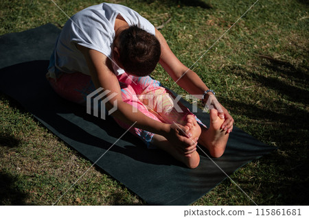 Woman practicing yoga in outdoor garden setting Woman practicing yoga in outdoor garden setting 115861681
