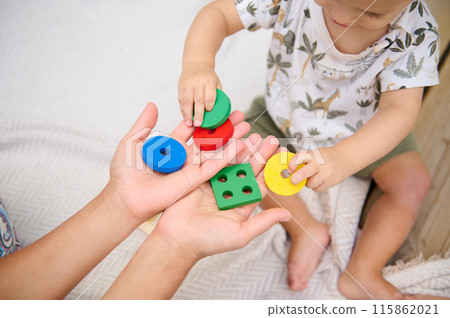 Parent and child playing with colorful educational toys together Parent and child playing with colorful educational toys together 115862021
