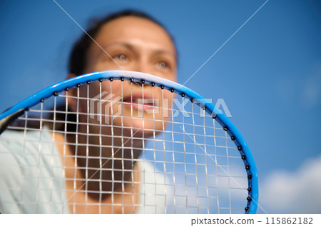 Female tennis player focusing on the game with racket close-up 115862182